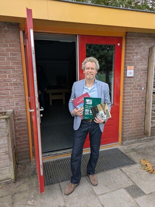 Thomas van Duin, laat, na de lezing, de boeken over onze wijk zien