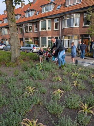 Samen met enkele jonge buurtbewoners legde Sander La Grouw de krans bij de Vredesboom.