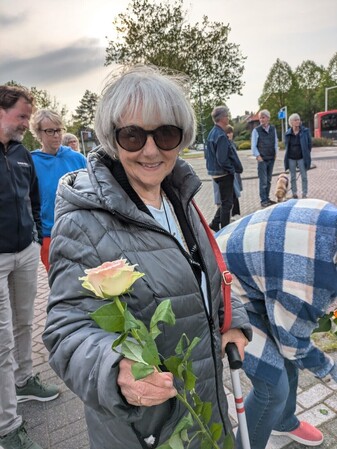 Mevrouw Reinhart legt een roos bij de Vredesboom 